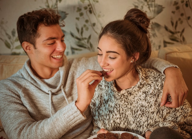 Free photo happy man feeding woman with sweets